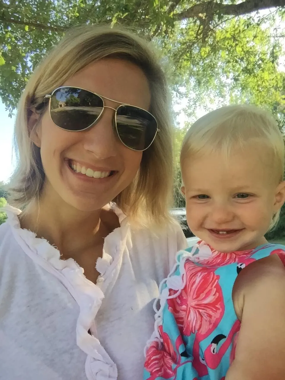 Emily in sunglasses smiling with Ellie outdoors